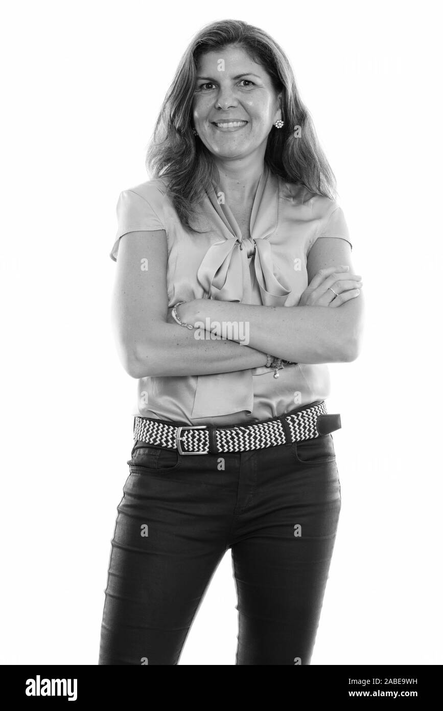 Studio shot of young woman smiling and standing with arms crossed Banque D'Images Studio shot of young woman smiling and standing with arms crossed Banque D'Images