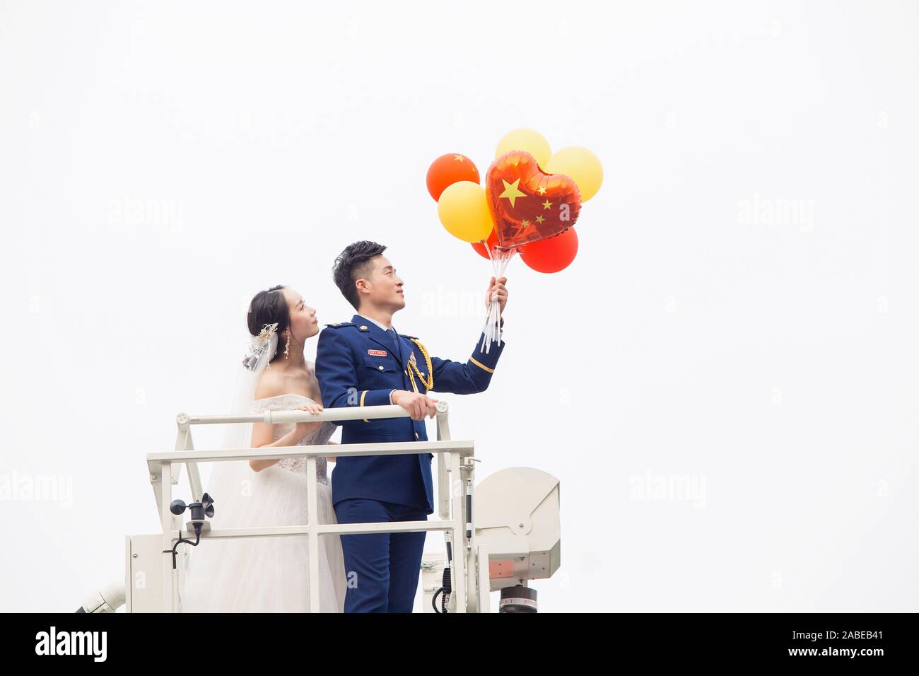 Fireman Jia Jie et sa femme prennent des photos avec l'aide de ses collègues en face d'un camion de lutte contre l'incendie de la ville de Chengdu, dans le sud-ouest de la Chine. Banque D'Images