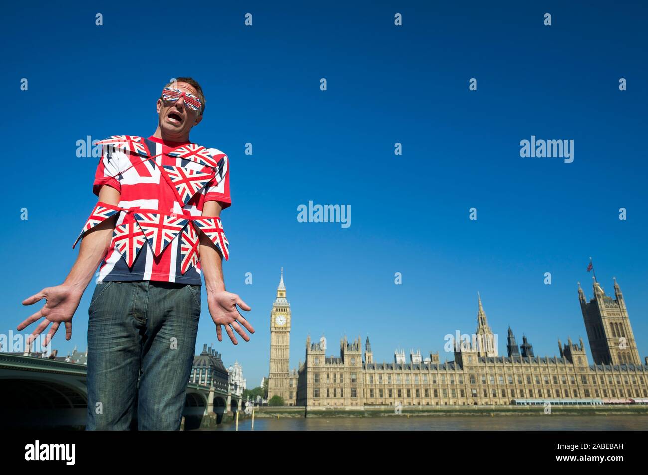 La confus enchevêtré dans l'homme Union Jack colorés bunting debout devant les toits de la ville de Westminster, London, UK Banque D'Images