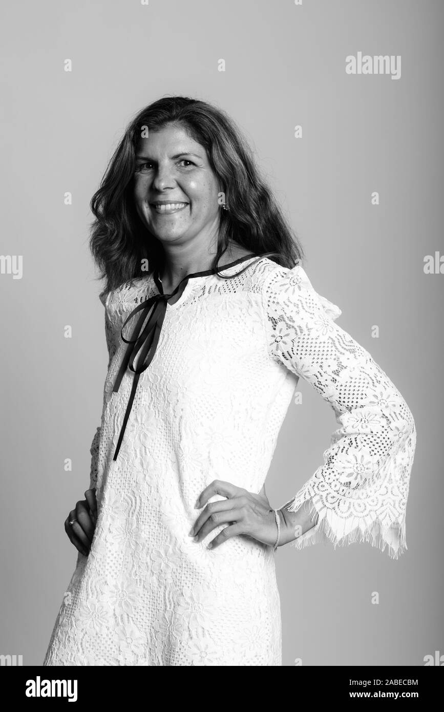 Studio shot of young woman smiling and posing with hands on hips Banque D'Images