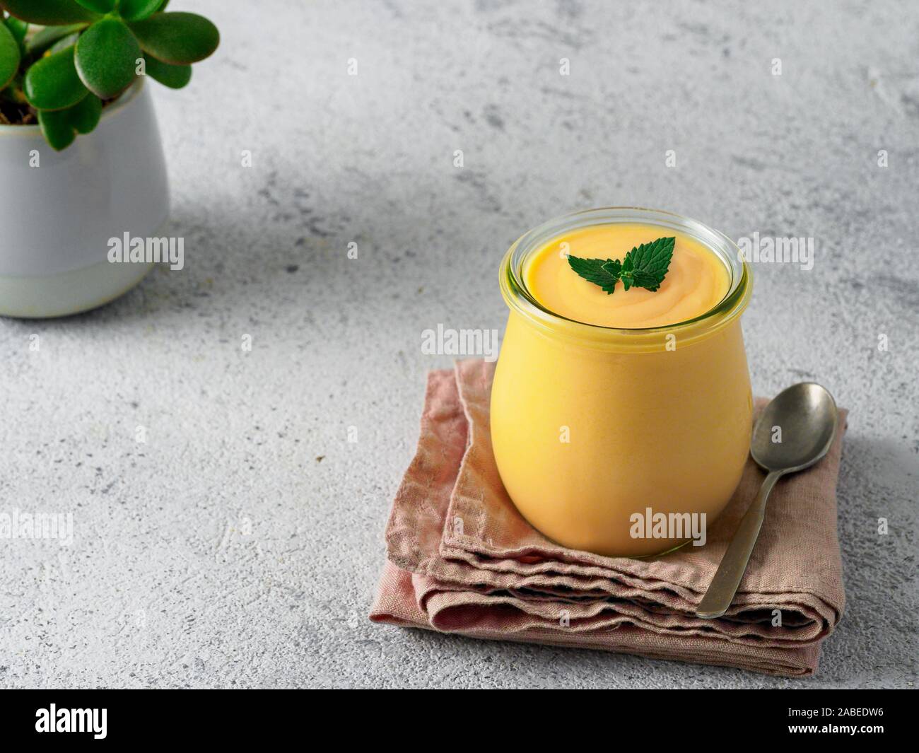 Lassi à la mangue jaune sur fond gris. Drink yaourt mangue indienne avec copie espace gauche. Banque D'Images