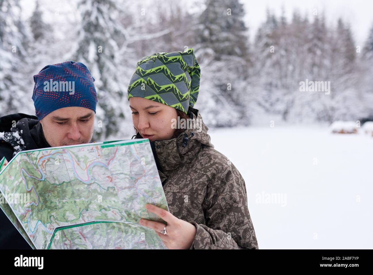 Couple reading a map lors d'une randonnée en hiver Banque D'Images