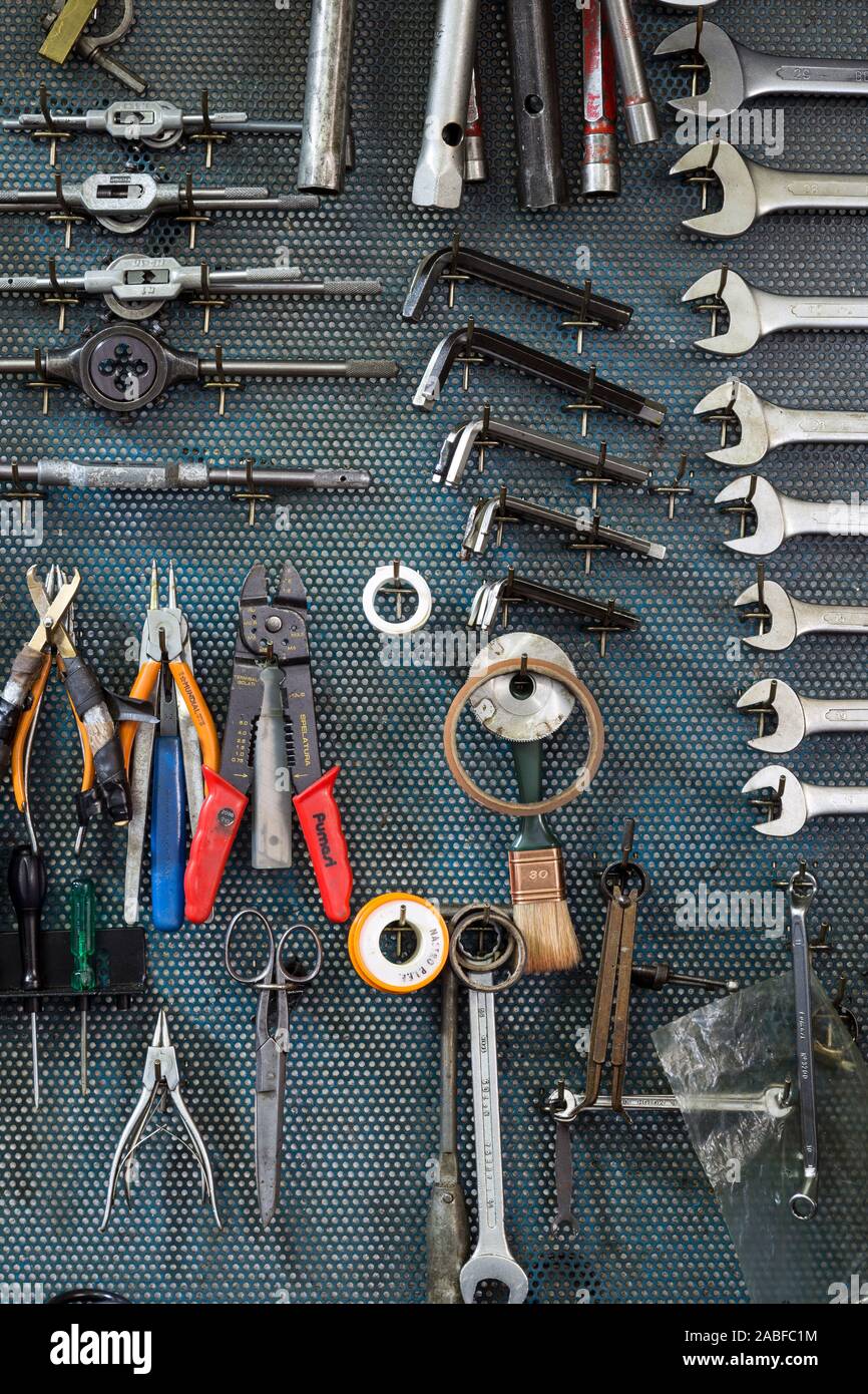 Détail d'un mur avec plusieurs ustensiles et outils dans un garage Banque D'Images