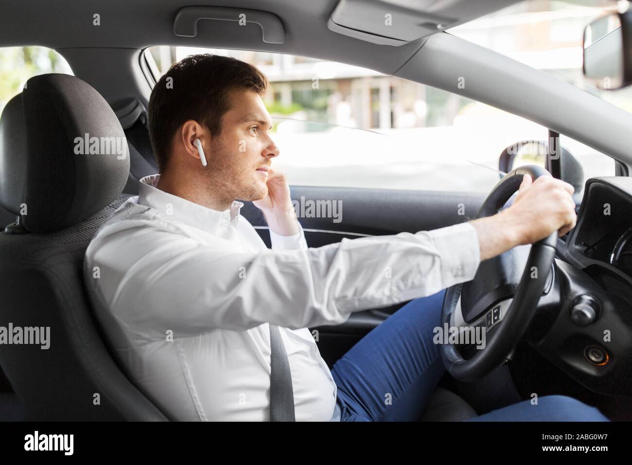 L'homme ou le pilote avec écouteurs sans fil voiture conduite Photo Stock -  Alamy