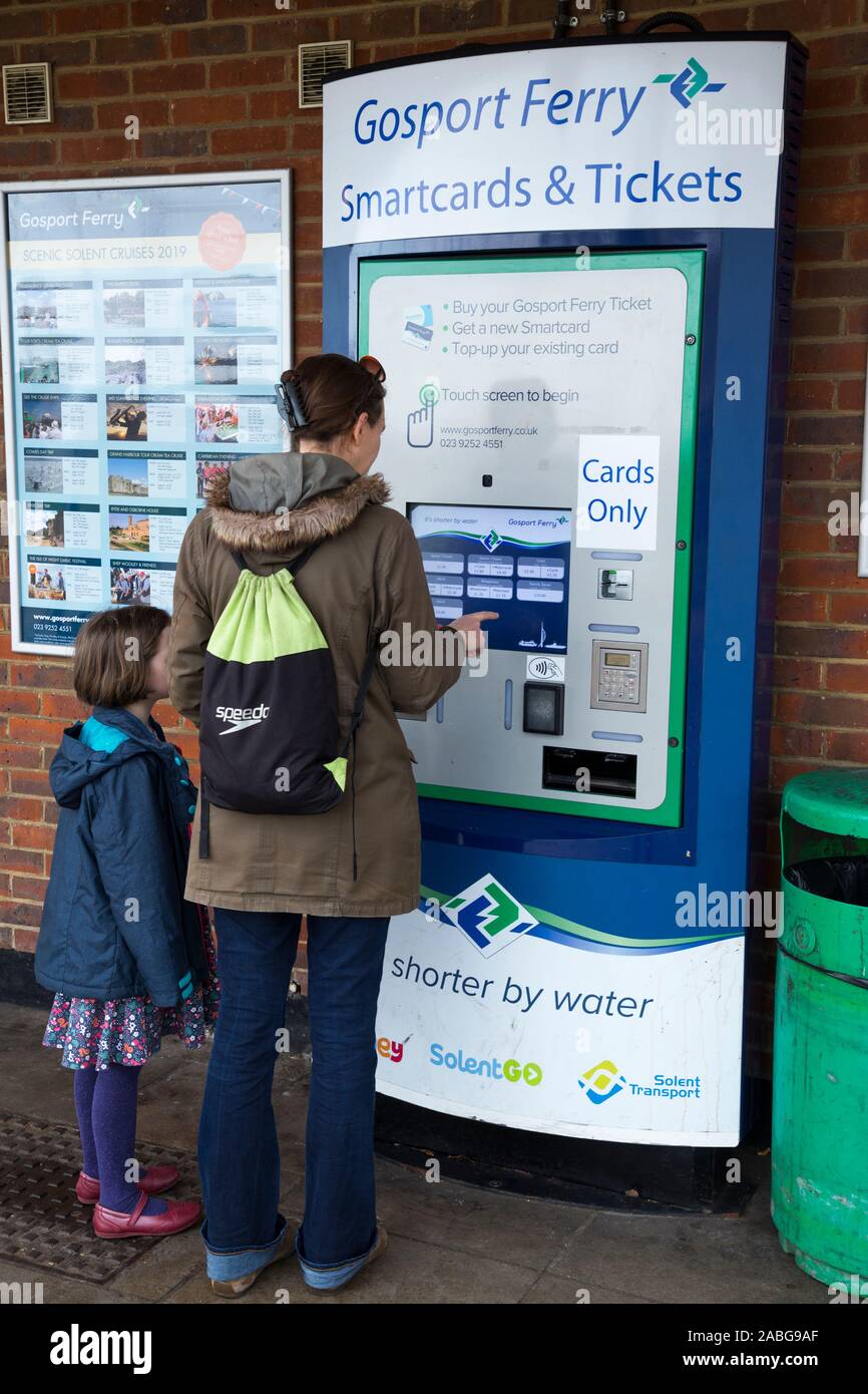 Passagère / dame à l'enfant l'achat de billets d'un seul distributeur de  cartes pour elle et sa fille de se rendre à Portsmouth sur le Gosport Ferry  dans le Hampshire. Royaume-uni (105