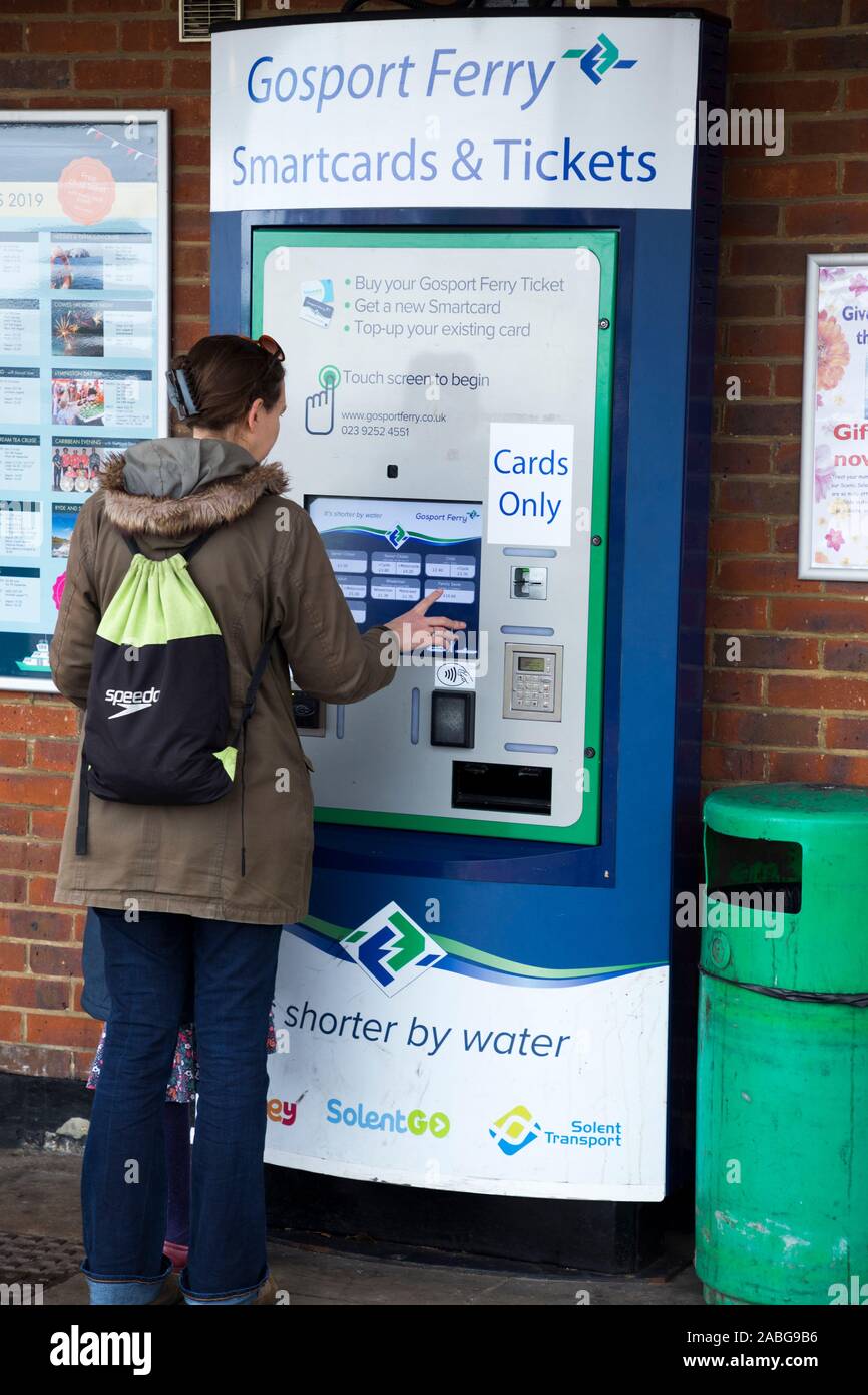 Passagère / dame le choix, la sélection, et l'achat de billets d'un seul distributeur de cartes pour elle-même de se rendre à Portsmouth sur le Gosport Ferry dans le Hampshire. Royaume-uni (105) Banque D'Images