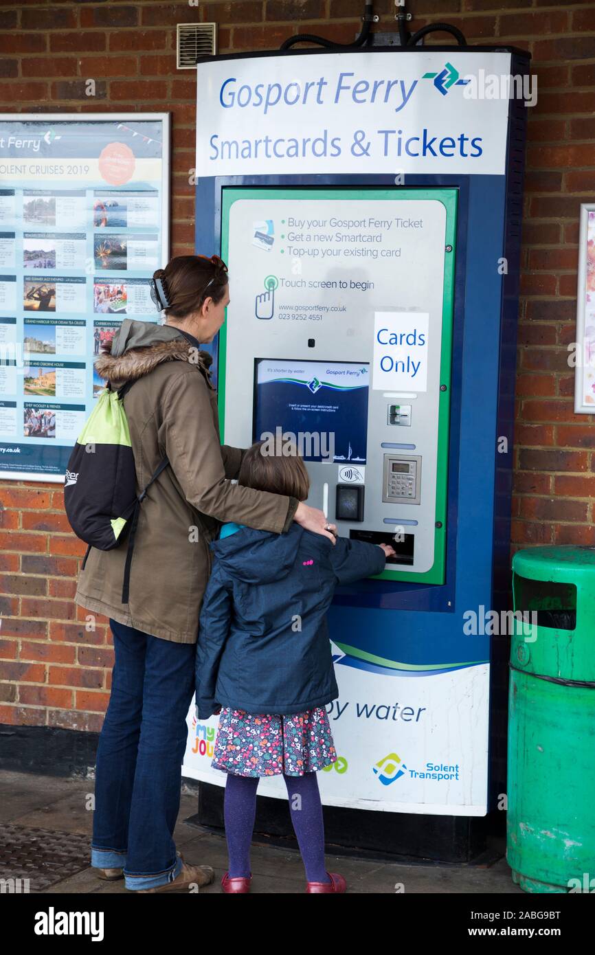 Passagère / dame à l'enfant l'achat de billets d'un seul distributeur de cartes pour elle et sa fille de se rendre à Portsmouth sur le Gosport Ferry dans le Hampshire. Royaume-uni (105) Banque D'Images