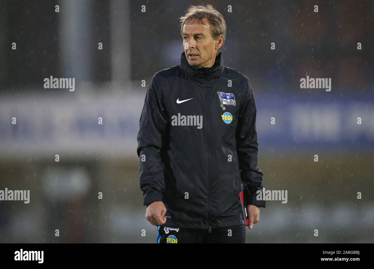 Berlin, Allemagne. 27 Nov, 2019. Soccer : Bundesliga Hertha BSC, première formation après changement d'entraîneur dans le stade sur le lieu de lancer/Amateurstadion. Le nouvel entraîneur Jürgen Klinsmann marche à travers le terrain avec un ordinateur portable dans la pluie. Crédit : Andreas Gora/dpa/Alamy Live News Banque D'Images