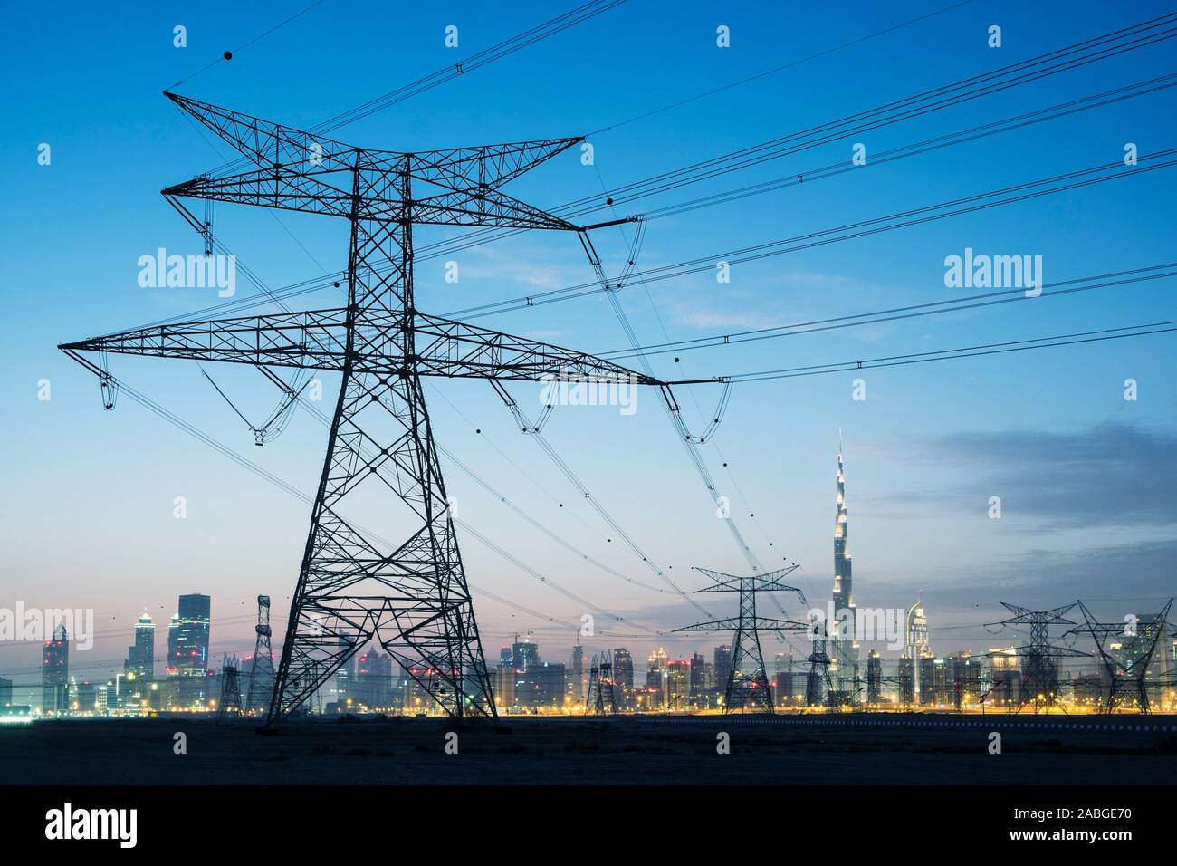 Lignes de transport d'électricité et les pylônes et skyline at Dusk à Dubaï Émirats Arabes Unis Banque D'Images