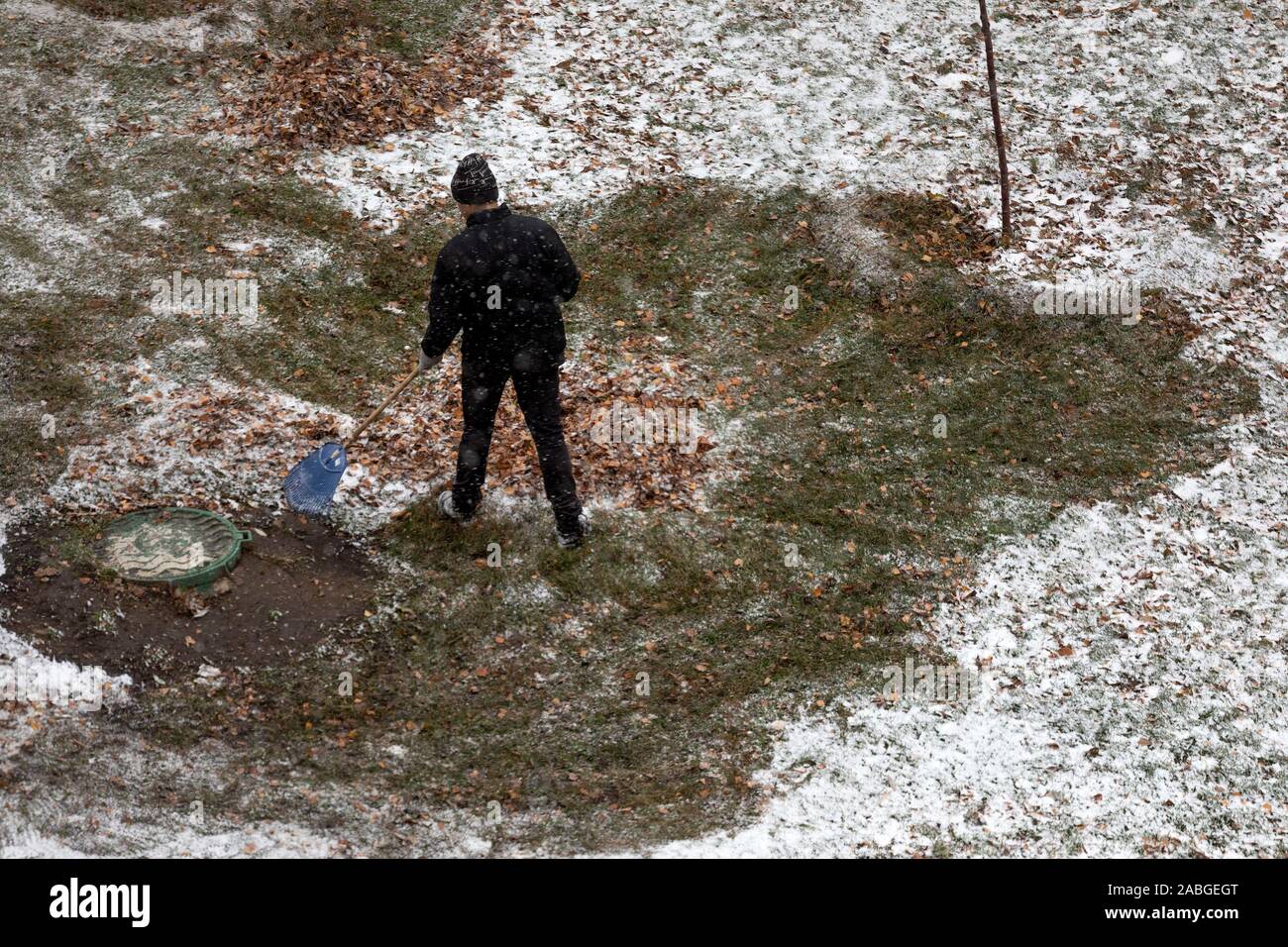 Un employé de l'utilitaire supprime le feuillage sur la région de la ville de Moscou au cours de la première neige, Russie Banque D'Images