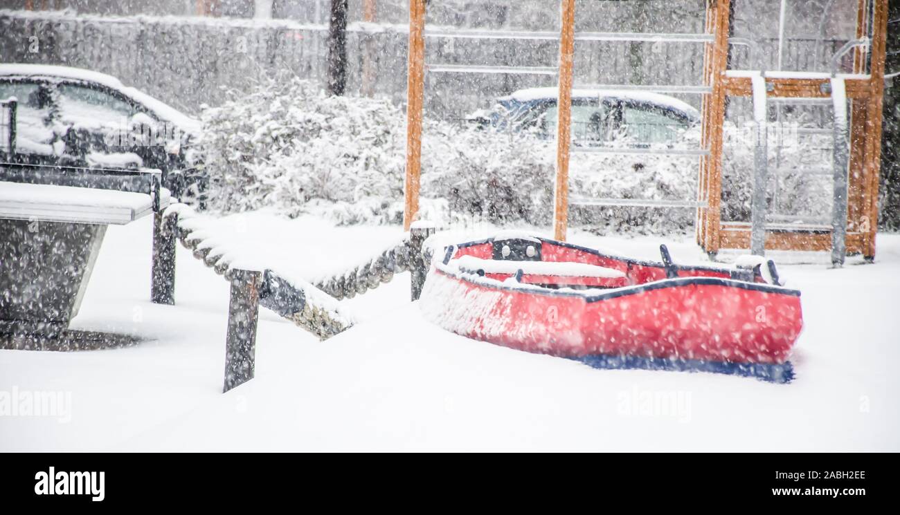 Terrain de jeu pour enfants avec un jouet rouge voile dans la neige Banque D'Images