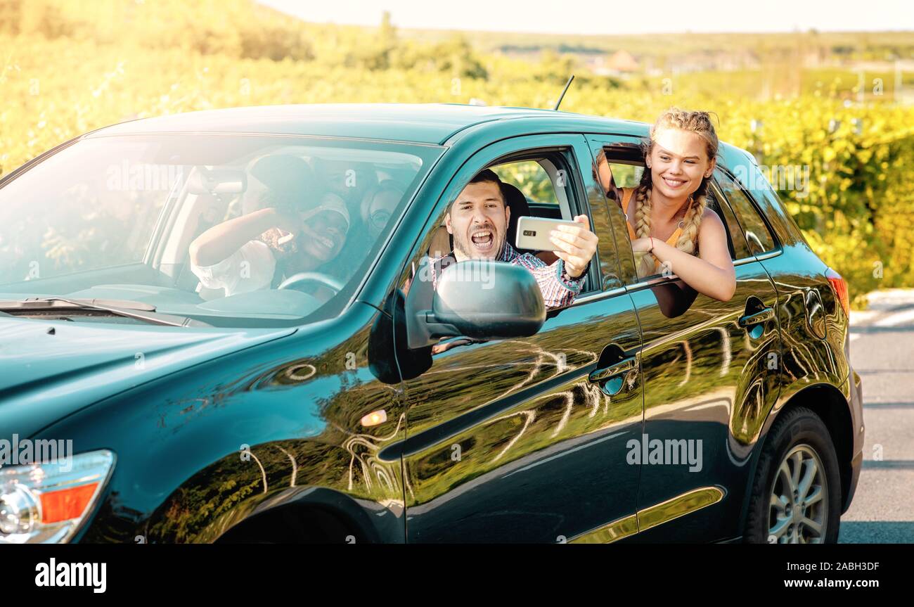 Heureux les jeunes femmes et l'homme jouissant d'un conducteur routier de l'été voyage ensemble. Road Trip Hangouts. Banque D'Images