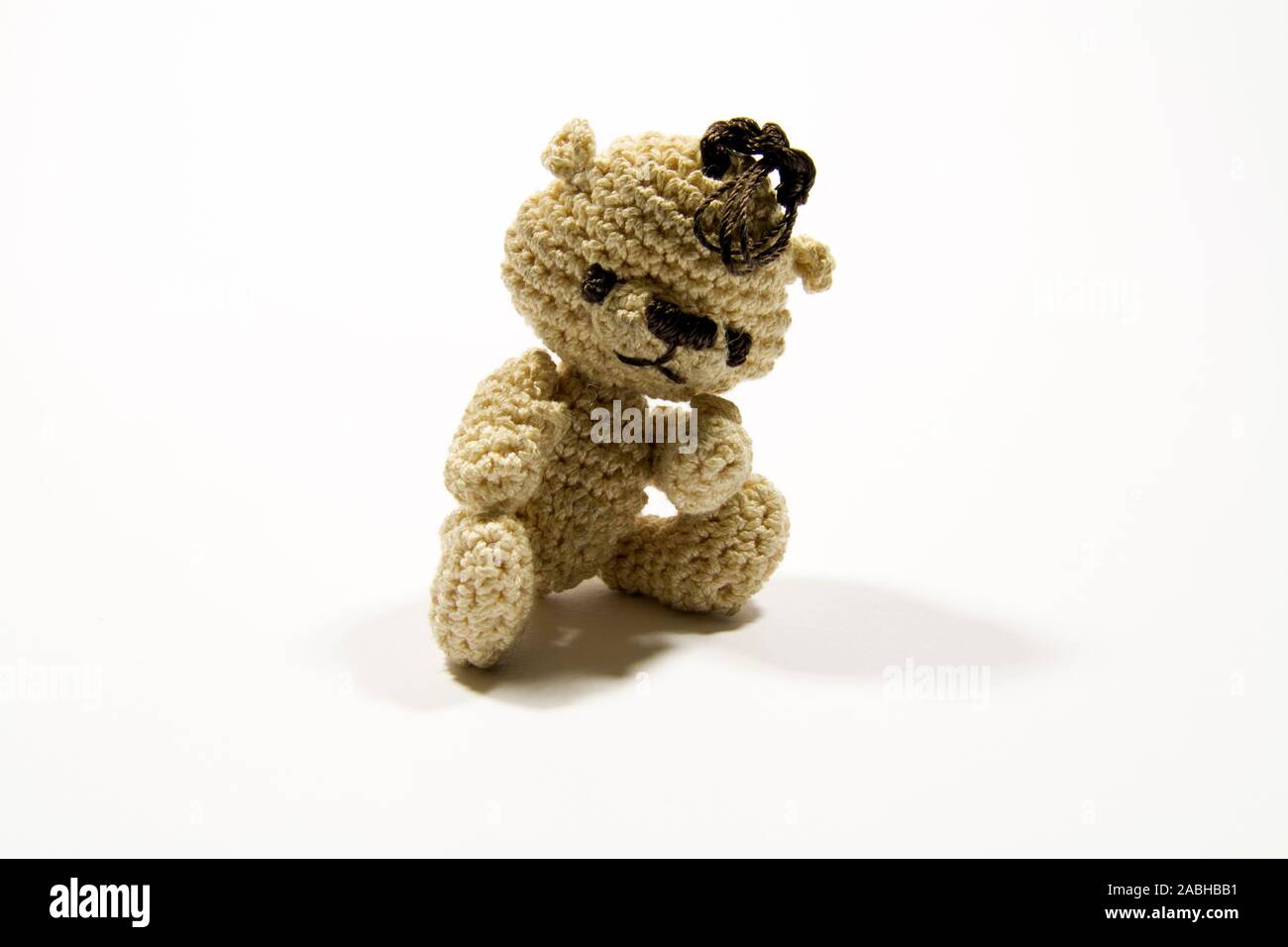 Crochet brun mignon ours en peluche avec fond blanc Banque D'Images