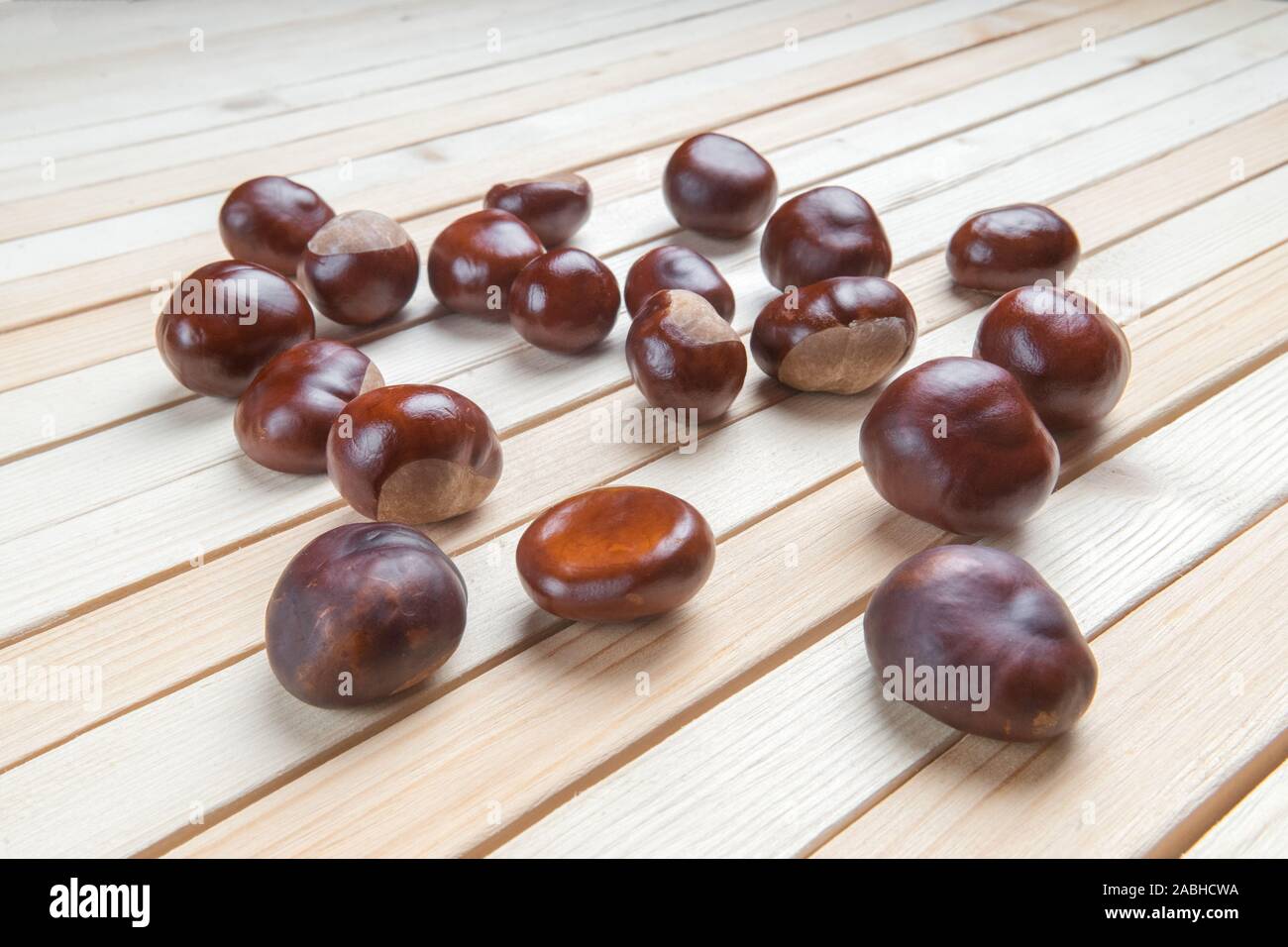 Dispersés sur une table en bois haut de la pile de fruits châtaignes. Banque D'Images