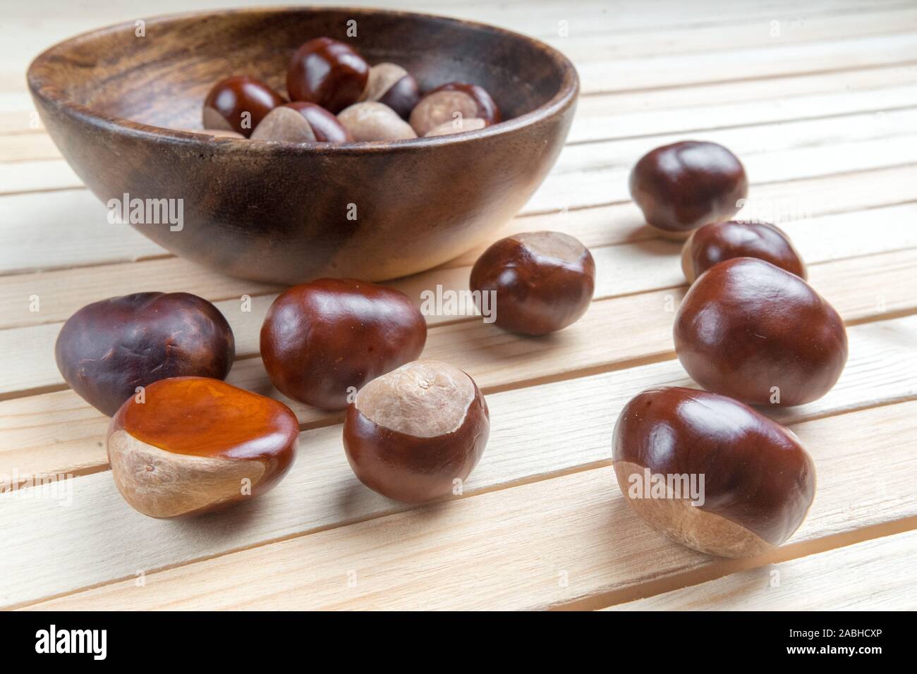 Dispersés dans le plat sur la table en bois haut de la pile de fruits châtaignes. Banque D'Images