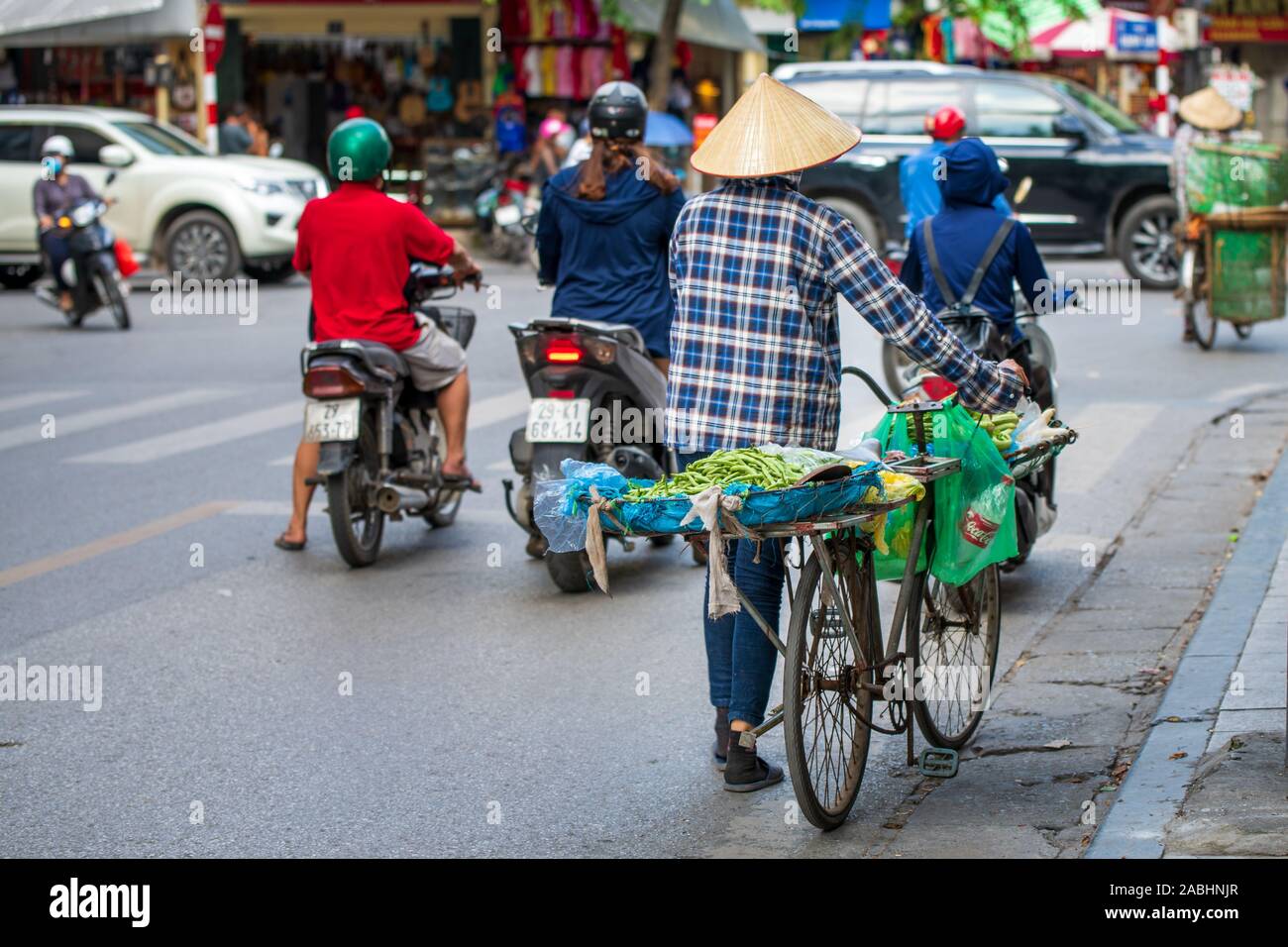 Hanoi, Vietnam - 11 octobre 2019 : Un vendeur de rue en tenant autour de fruits sur sa moto à vendre dans la ville Banque D'Images