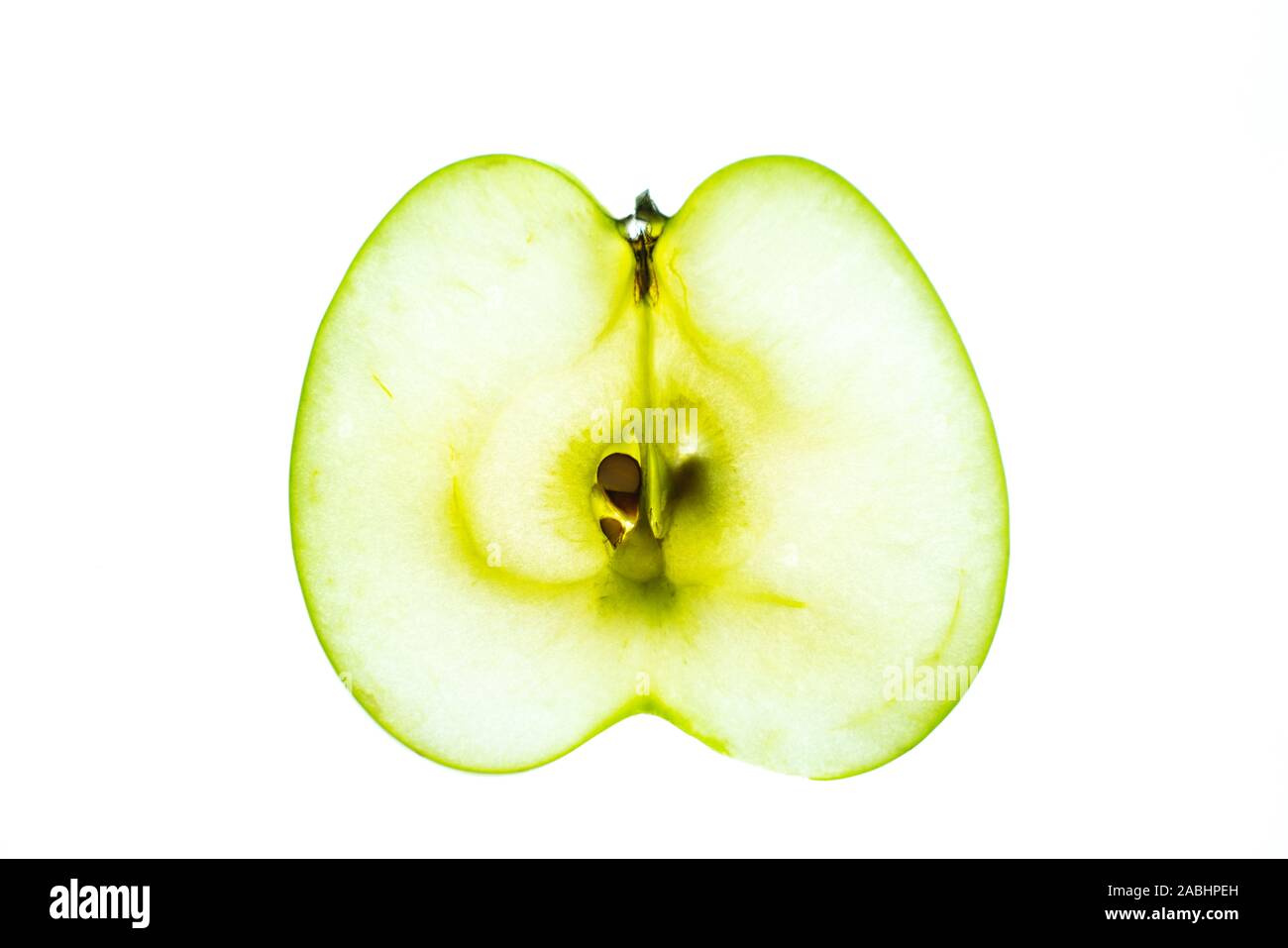Section transversale lumineuse translucide de la pomme verte isolée sur fond blanc Banque D'Images