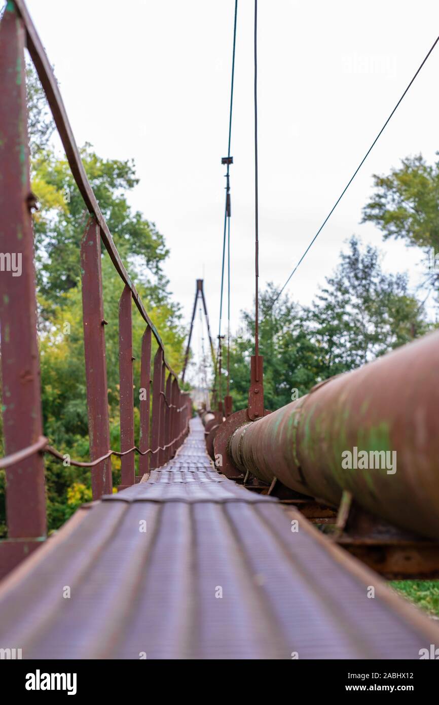 Un étroit passage de la rivière old rusty, ainsi qu'un tuyau d'eau et de gaz.  Les communications dans le village Photo Stock - Alamy