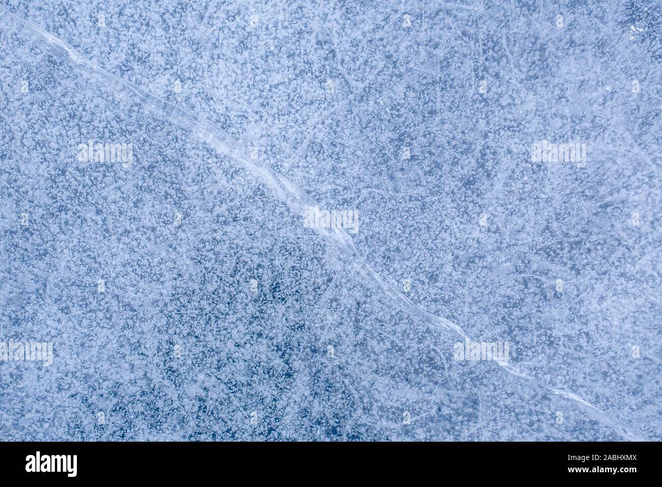 Beau fond glacé avec bulles emprisonnées dans la glace gelée. Vue sans fin sur la surface de l'étang ou lac. Banque D'Images