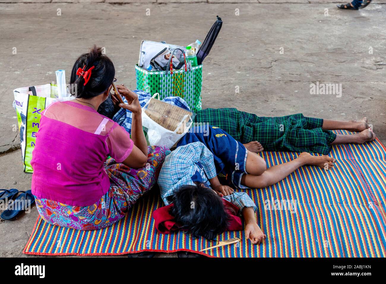Les personnes qui dorment sur la plate-forme de la gare de Yangon, Yangon, Myanmar. Banque D'Images