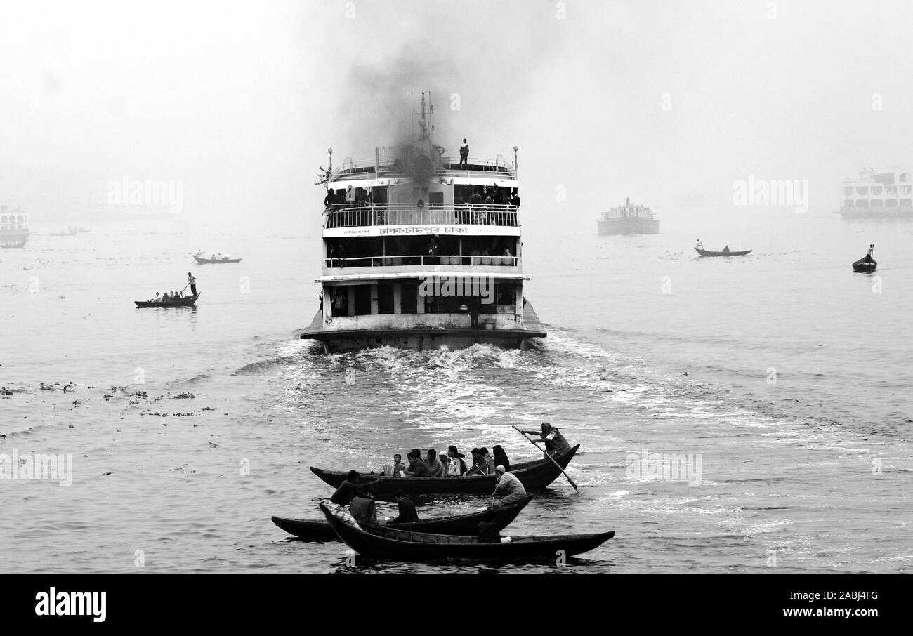 Bangladesh - janvier 06, 2014 : les bateliers transportent des passagers dans l'après-midi d'hiver brumeux sur la rivière Buriganga. Banque D'Images Bangladesh - janvier 06, 2014 : les bateliers transportent des passagers dans l'après-midi d'hiver brumeux sur la rivière Buriganga. Banque D'Images