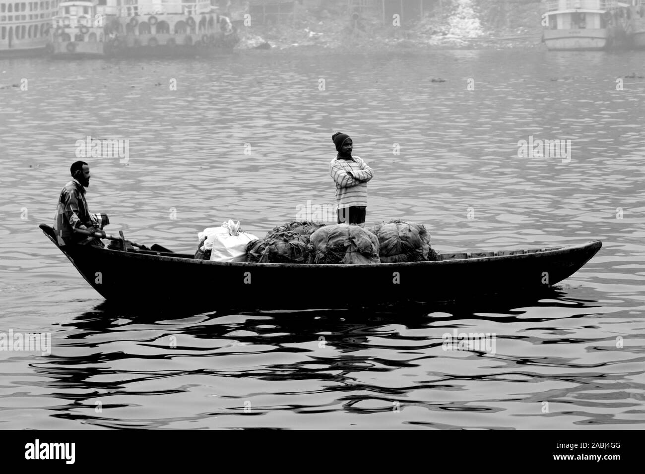 Bangladesh - janvier 06, 2014 : les bateliers transportent des passagers dans l'après-midi d'hiver brumeux sur la rivière Buriganga. Banque D'Images Bangladesh - janvier 06, 2014 : les bateliers transportent des passagers dans l'après-midi d'hiver brumeux sur la rivière Buriganga. Banque D'Images