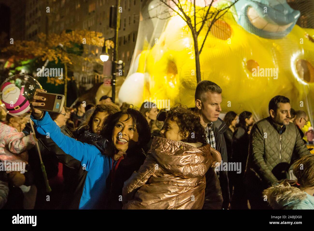 New York, NY, USA. 27 Nov, 2019. Des milliers de spectateurs paniers les rues autour de l'American Museum of Natural History pour voir le domaine de l'inflation pour les ballons pour Macy's Thanksgiving Day Parade. Une femme et une fille poser pour une en face de selfies Spongebob Squarepants. Credit : Ed Lefkowicz/Alamy Live News Banque D'Images