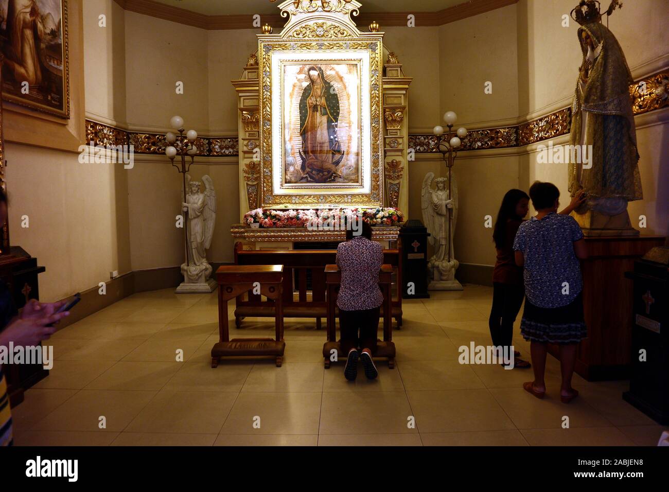 Antipolo City, Philippines - 26 novembre 2019 : dévots catholiques à prier sur un autel statues religieuses à l'intérieur de la cathédrale ou l'Antipolo Notre Dame Banque D'Images