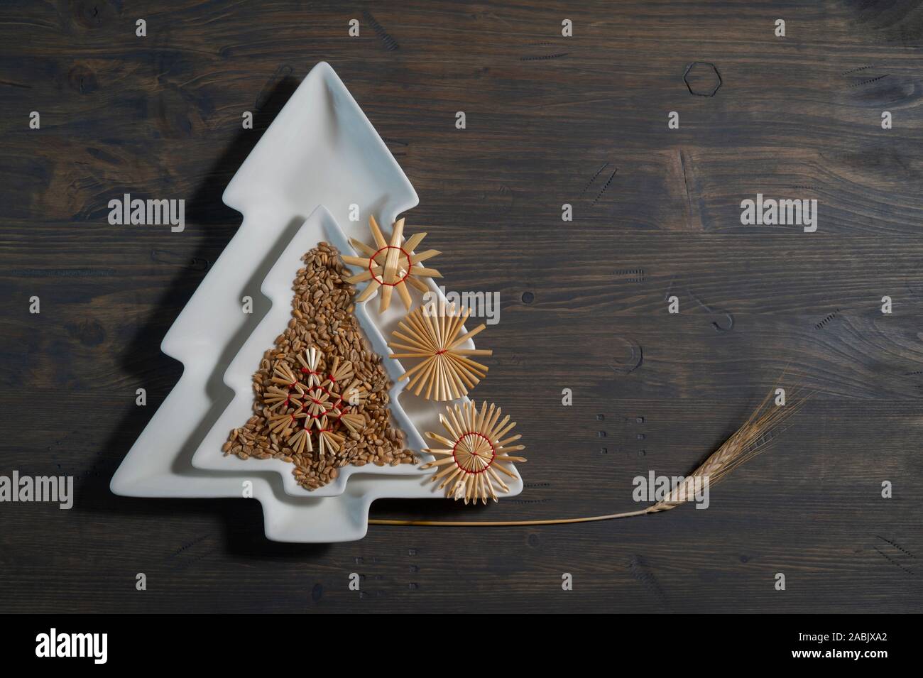 Deux plaques de forme d'arbres de Noël décorative située au-dessus de chaque autre décoré avec des graines naturelles, des décorations de paille et l'épi de blé ove Banque D'Images