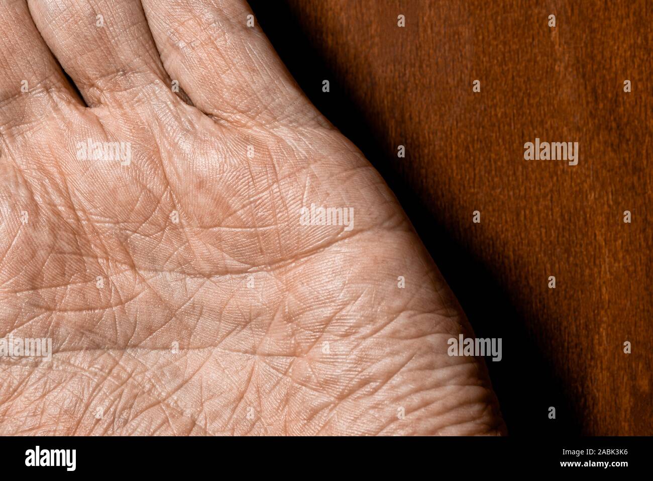 Photo d'hommes âgés ayant les mains sur un fond de bois. Détail de la paume de la main. Banque D'Images