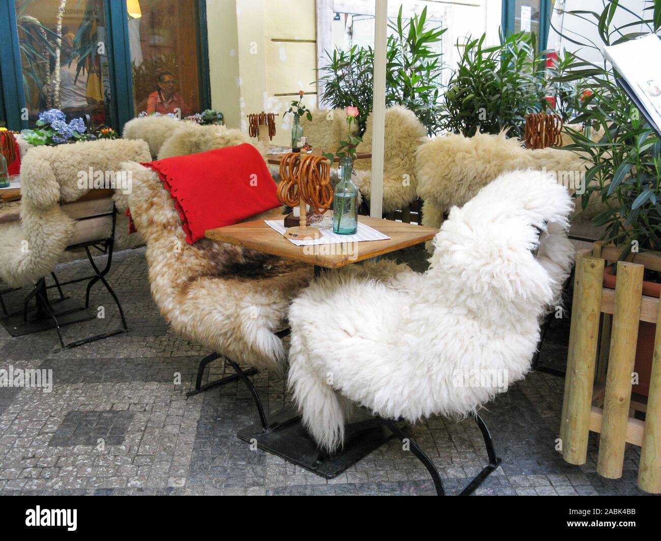 Chaleureuses, confortables chaises en acier couvrant les pelleteries de café restaurant en plein air à l'automne dans la vieille ville de Prague, République Tchèque Banque D'Images