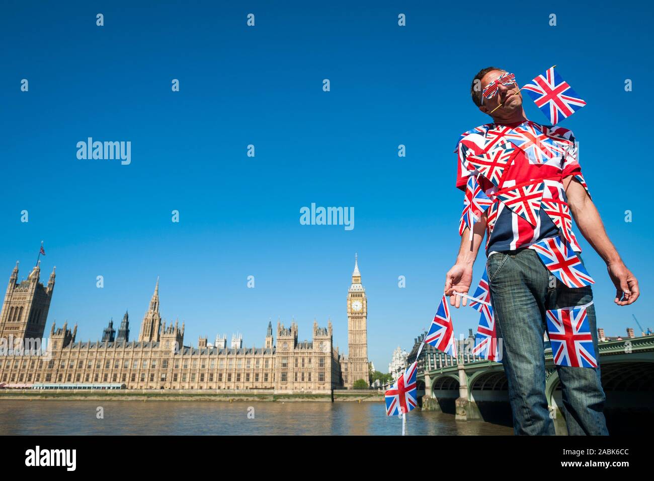 Immigrants européens confus enchevêtré dans British Union Jack flag bunting debout en face de la ville de Westminster, London, UK Banque D'Images