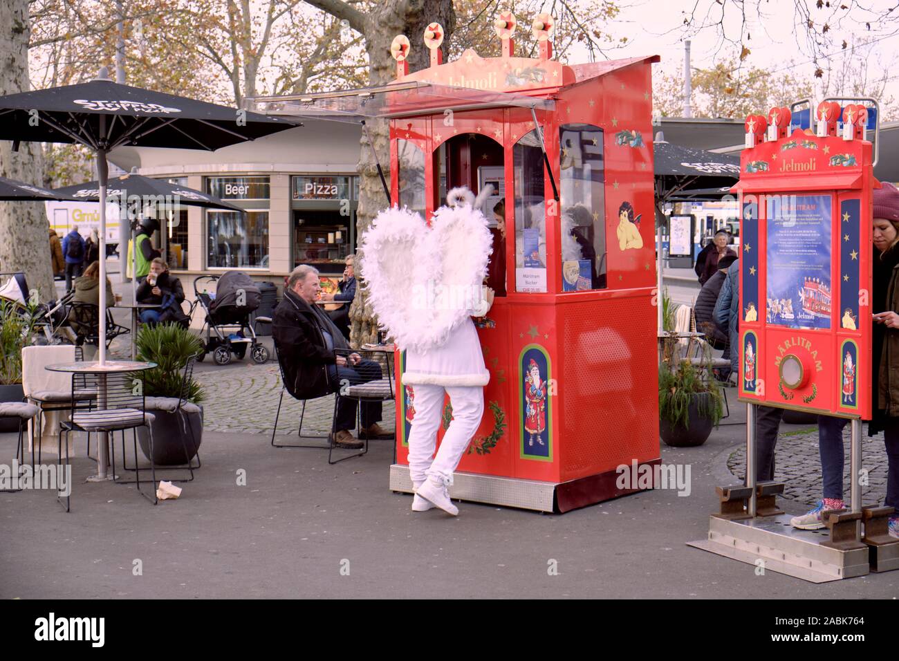 Femme en costume avec des ailes en forme de coeur debout à la billetterie pour le Marlitram à Zurich, Suisse, avec teinte rosée Banque D'Images