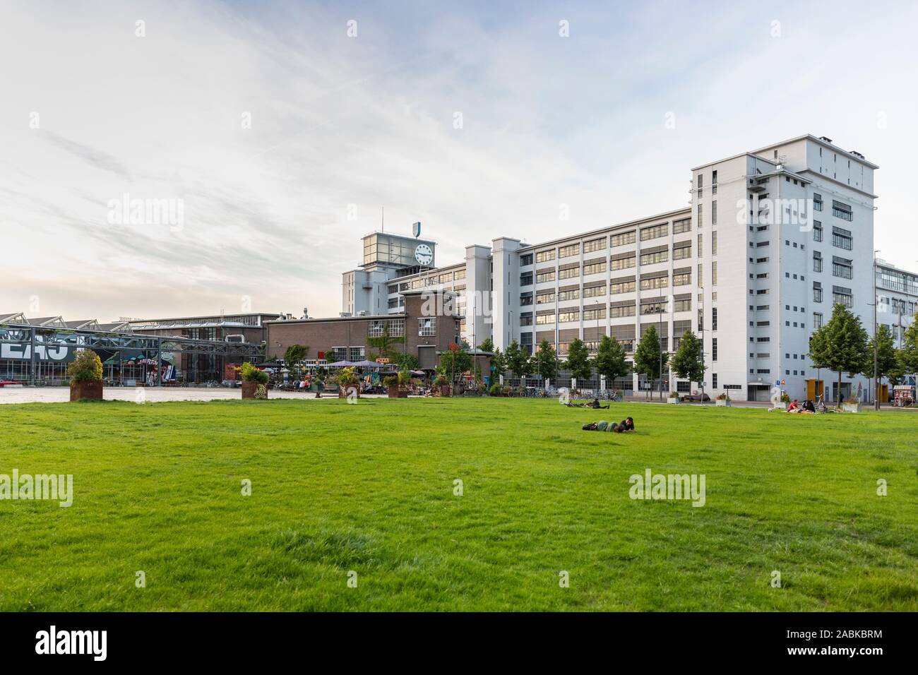 Eindhoven (Pays-Bas), le 1 juin 2019. L'klokgebouw et personnes portant sur la pelouse à côté de l'Ketelhuiplein sur Strijp S pendant le coucher du soleil. Banque D'Images