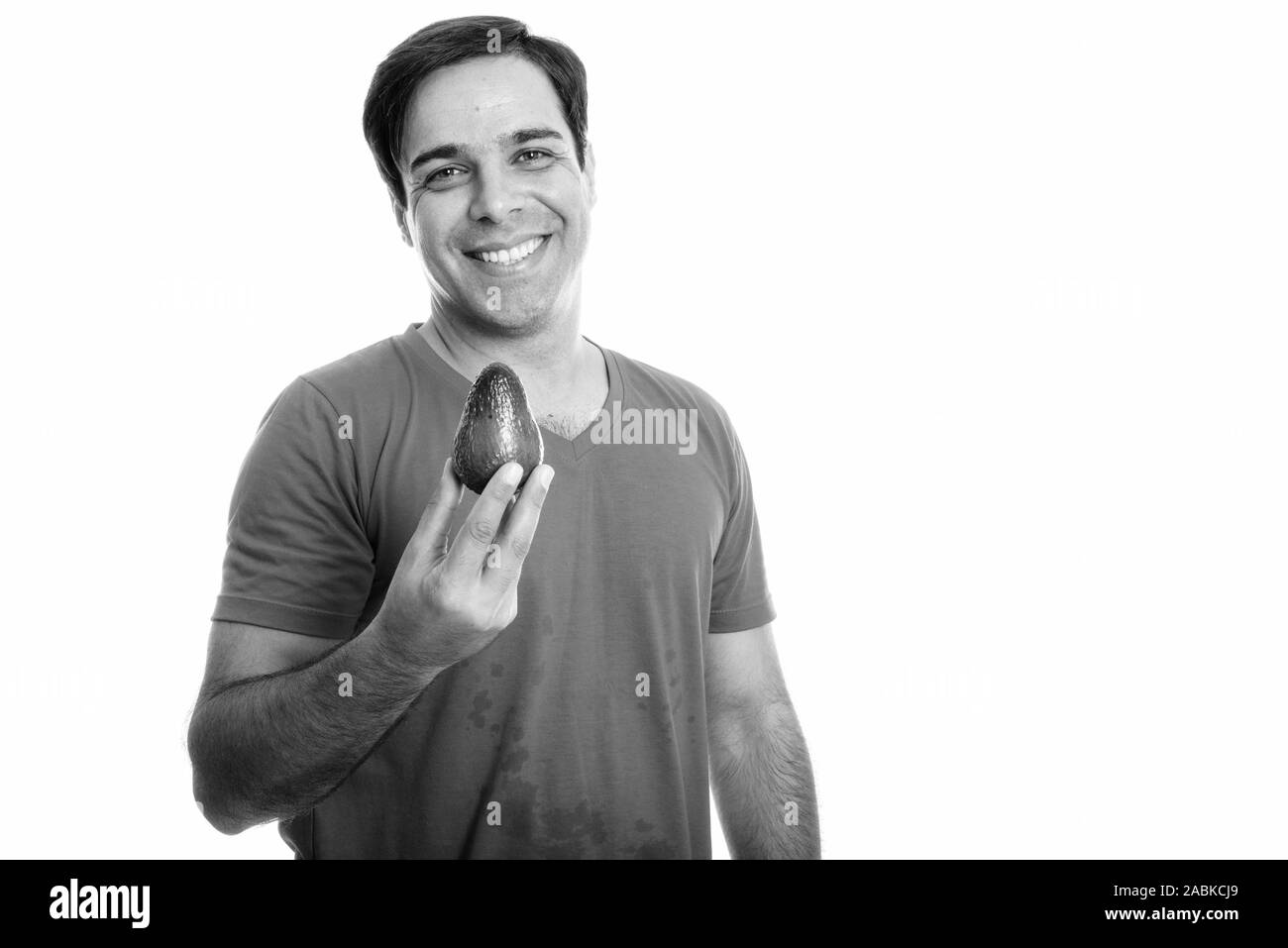 Studio shot of young man smiling persan heureux tout en maintenant l'avocat contre isolé sur fond blanc Banque D'Images