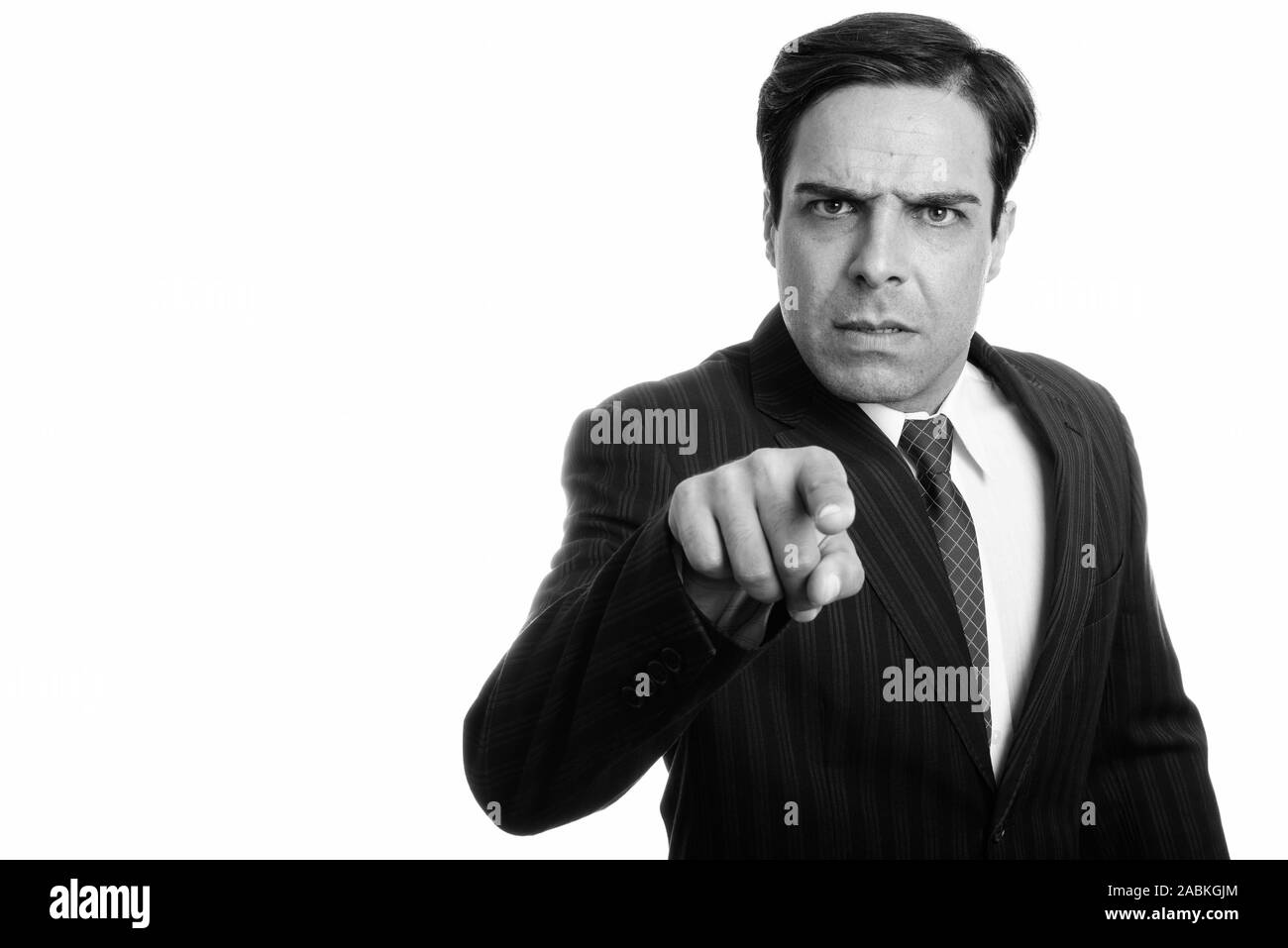 Studio shot of young businessman pointing at persan en colère isolé de l'appareil photo contre fond blanc Banque D'Images