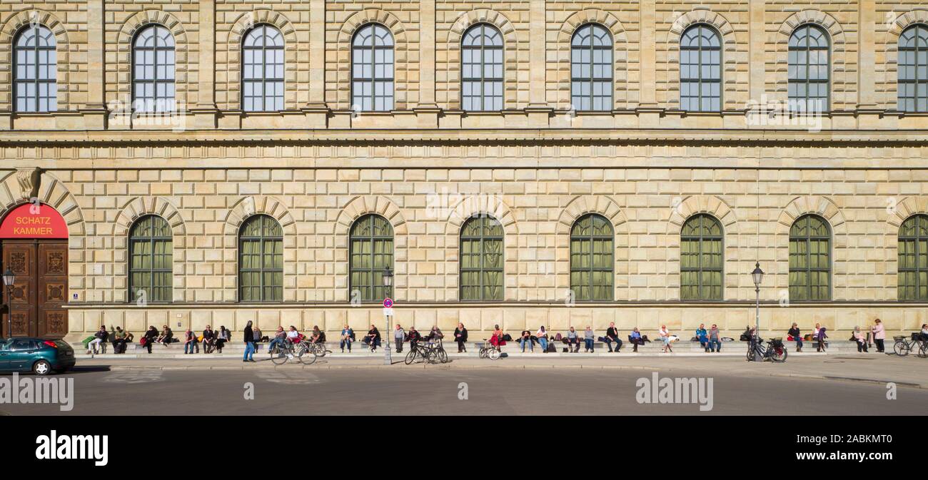 Les amoureux du soleil s'asseoir sur les marches de la résidence à Max-Joseph-Platz sur un jour de février. [Traduction automatique] Banque D'Images