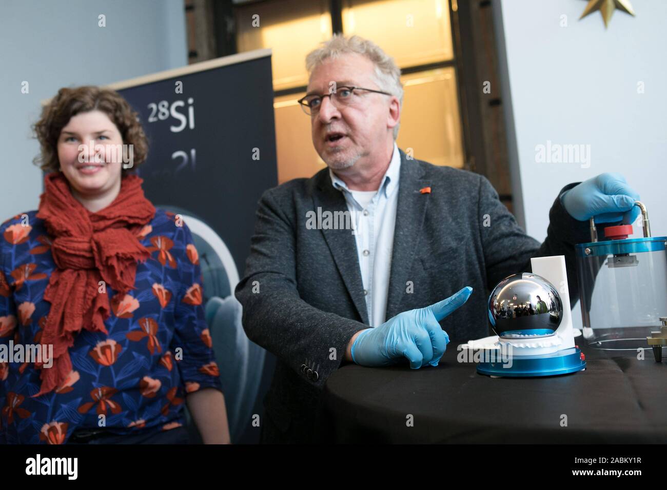 Le Musée Allemand de Munich présente un sol parfaitement sphère de silicium qui servira de référence pour un kilo de taille dans l'avenir. Jens Simon, porte-parole à l'Institut fédéral de physique et de technologie, les points de la sphère de silicium. À côté de lui : Conservateur Daniela Schneevoigt. [Traduction automatique] Banque D'Images