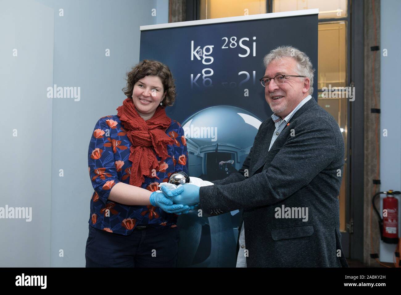 Le Musée Allemand de Munich présente un sol parfaitement sphère de silicium qui servira de référence pour un kilo de taille dans l'avenir. Jens Simon, porte-parole de l'Institut fédéral de physique et de technologie, a la balle de silicium dans sa main. À côté de lui : Conservateur Daniela Schneevoigt. [Traduction automatique] Banque D'Images