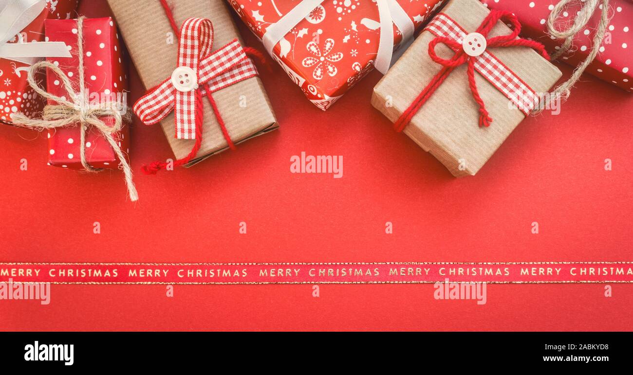 Carte de vœux de Noël avec les différents coffrets cadeaux sur fond rouge. Vue de dessus avec l'exemplaire de l'espace. Banque D'Images