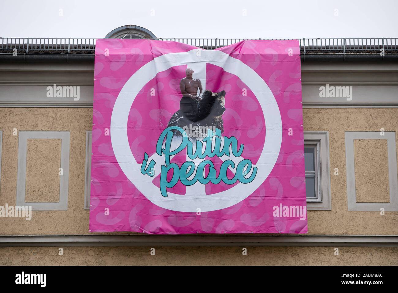 Poutine poster à la Prinzregentenstraße 65 construction à Munich. Au-dessus de la 'lettrage Poutine est la paix" et un grand symbole de paix sur un fond rose, le président russe Vladimir Poutine est représenté à cheval un ours avec son haut du corps gratuitement. [Traduction automatique] Banque D'Images