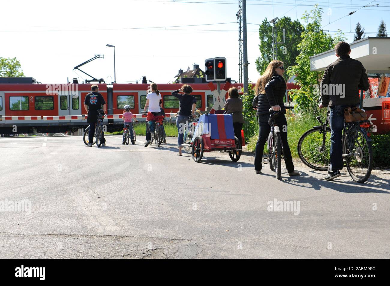 Les cyclistes attendre devant une barrière fermée à la S-Bahn crossing à  Daglfing. [Traduction automatique] Photo Stock - Alamy