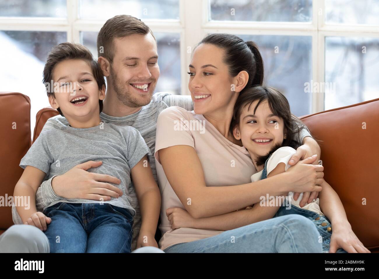 Famille heureuse avec les enfants d'âge préscolaire relaxing on couch Banque D'Images