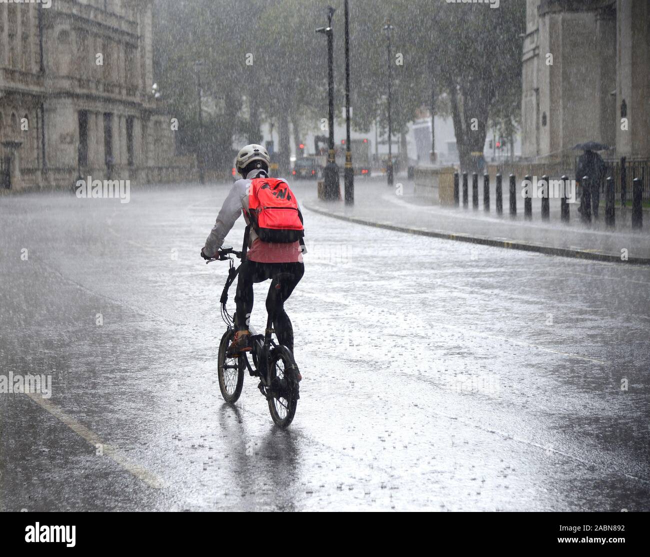 Londres, Angleterre, Royaume-Uni. Cycliste à la pluie torrentielle Banque D'Images