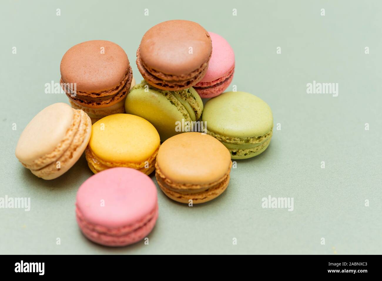 Plus de macarons savoureux de couleur un fond vert. Banque D'Images