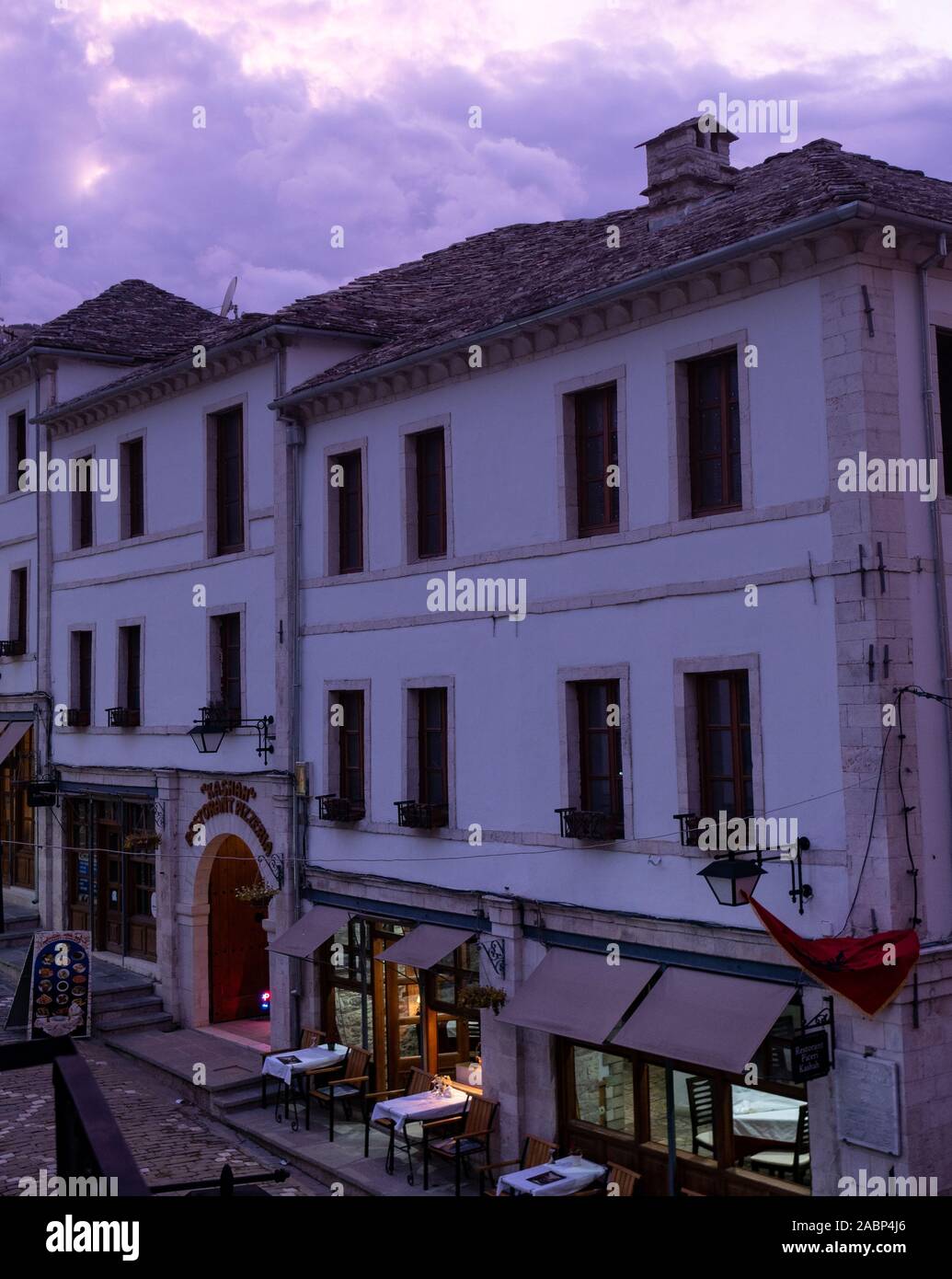 Saranda, Albanie - 26 septembre 2019 : scène de rue dans la vieille ville avec des stucs blanchis et restaurant au rez-de-chaussée avec tables en plein air un Banque D'Images