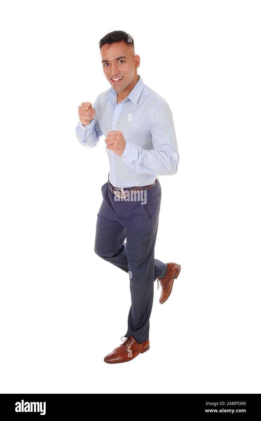 Un beau jeune homme en chemise bleue et pantalon de ville est en cours d'exécution dans le studio, isolée pour fond blanc Banque D'Images