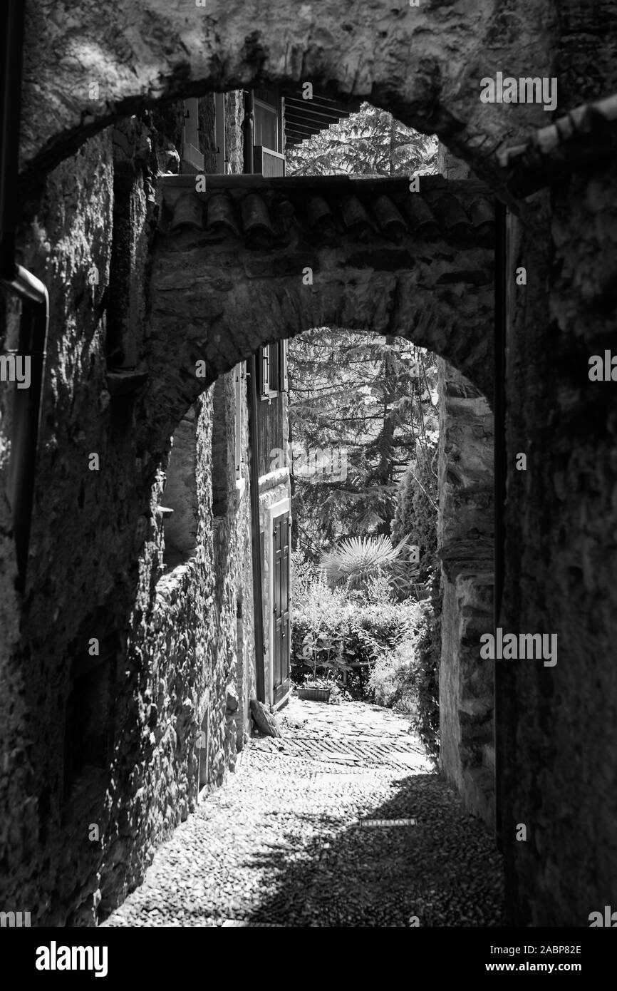 Via Ettore Fieramosca : un minuscule couloir voûté dans le village médiéval de Canale di Tenno, Trentino-Alto Adige, Italie. Version noir et blanc Banque D'Images