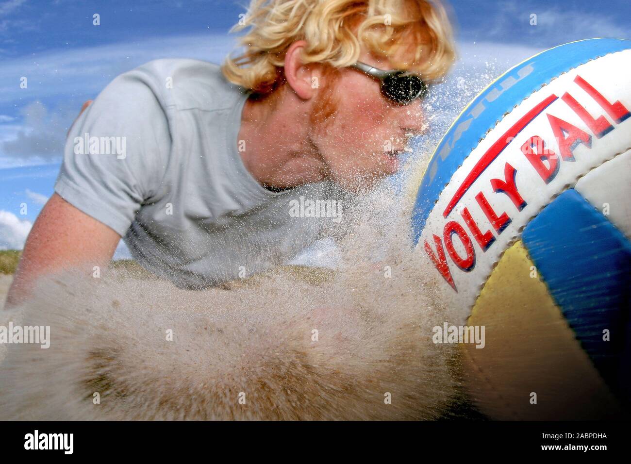 Junger Mann auf springt Beachvolleyball Banque D'Images