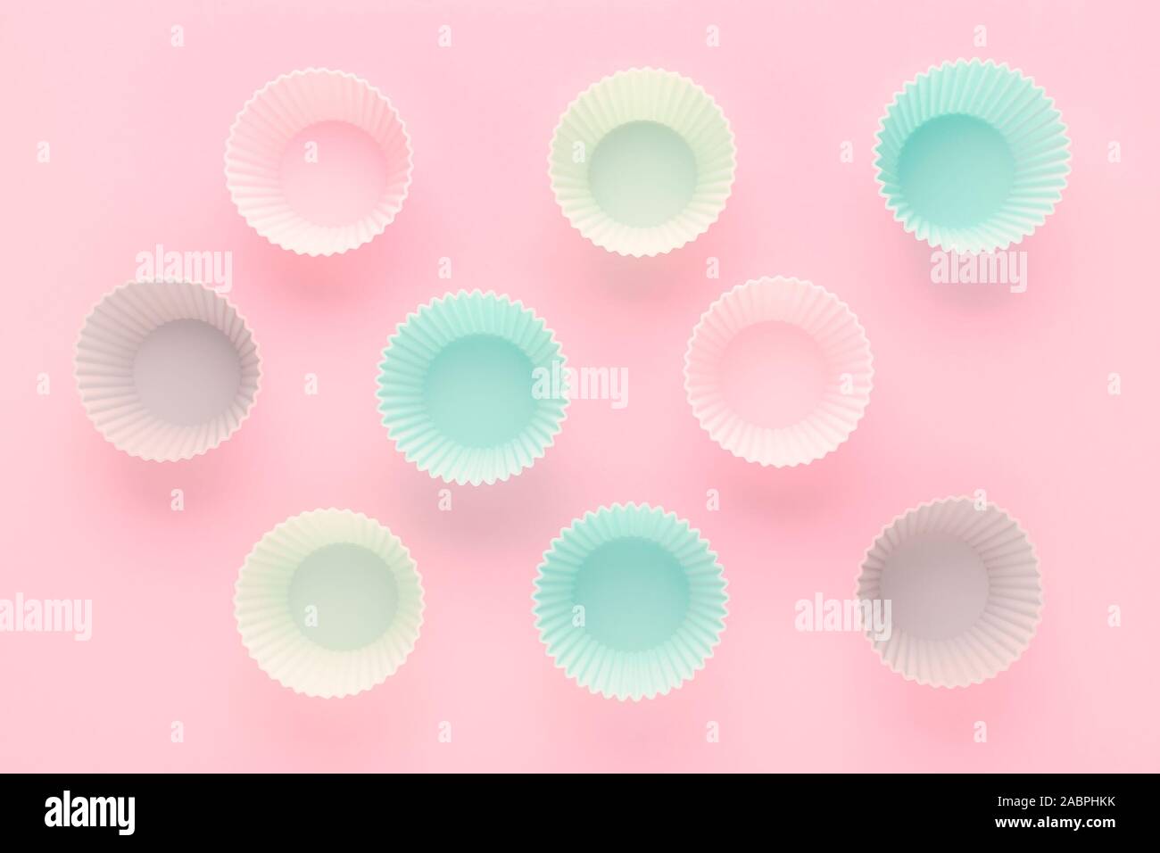 Formulaires pour la pâtisserie silikone muffins et cupcakes sur fond rose pastel Banque D'Images